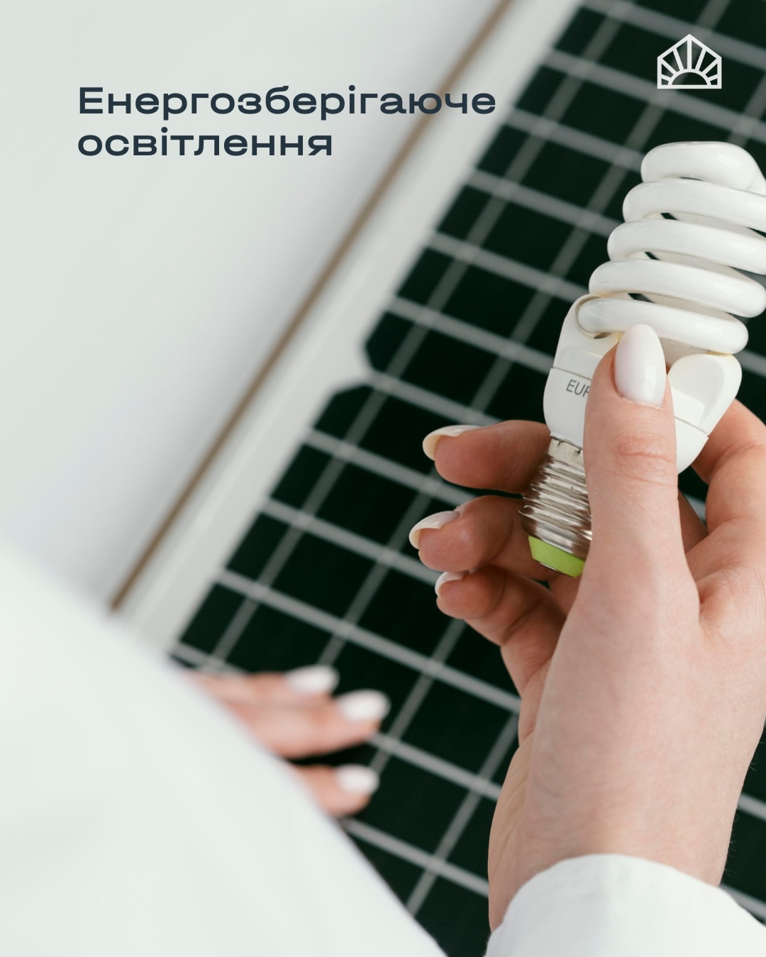 Banner promoting energy-saving lighting: a hand holds a compact fluorescent bulb with a solar panel in the background, and Ukrainian text about energy efficiency appears in the top left.