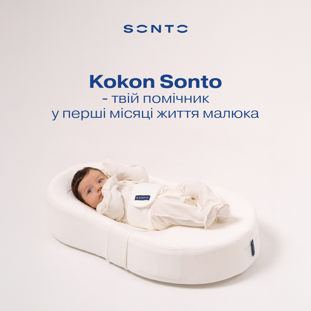 Newborn baby lying in a white cocoon-style baby lounger on a pale background with Kokon Sonto branding.