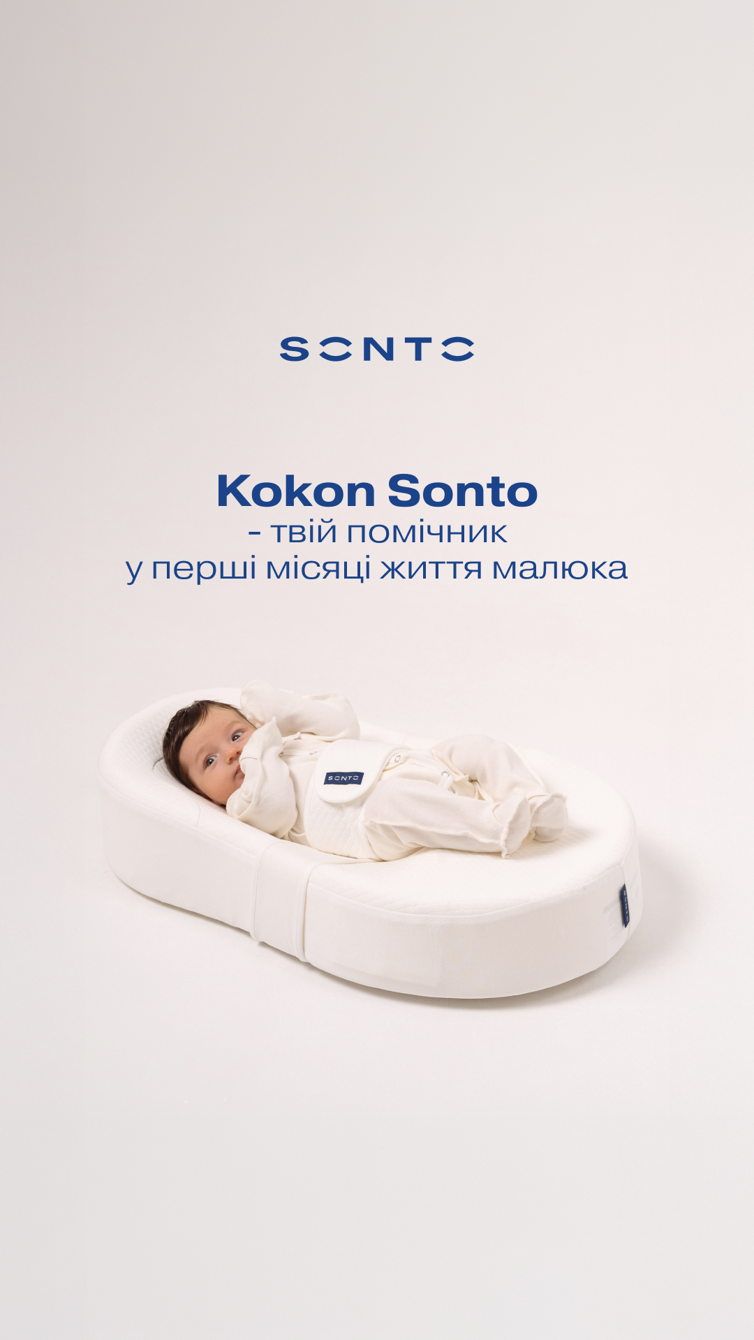 Baby in a white cocoon-style nest with blue branding and Ukrainian product text about Kokon Sonto.