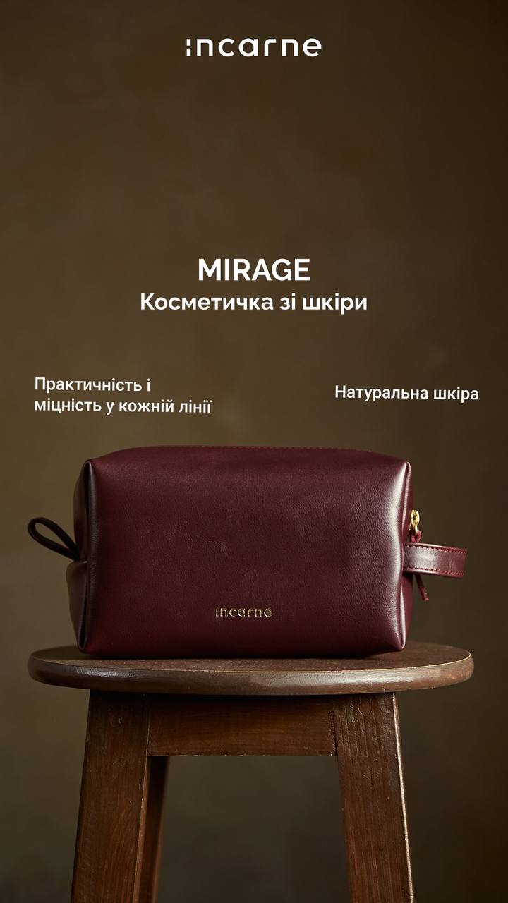 Cosmetic bag 'MIRAGE' in burgundy leather on a wooden stool, brand 'incarne' visible