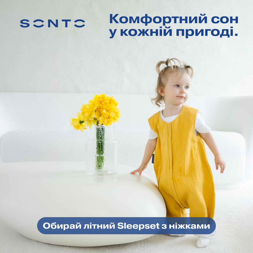 Advertisement banner with a toddler in a yellow sleepsuit beside a vase of yellow flowers; Ukrainian text promotes comfy sleep on adventures.