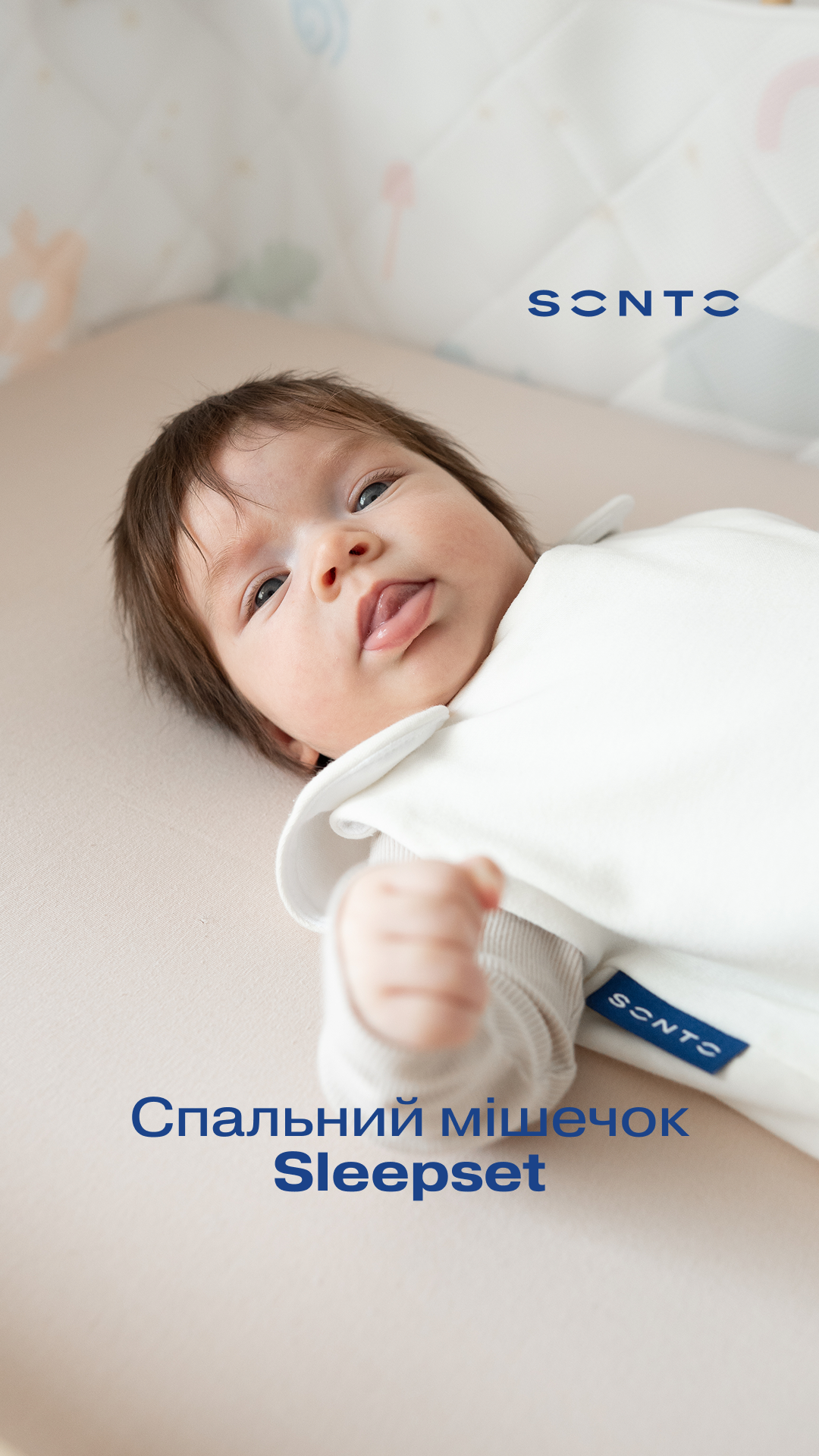 Baby lying on a pale bed in white sleepset; blue 'Sleepset' branding appears bottom center.