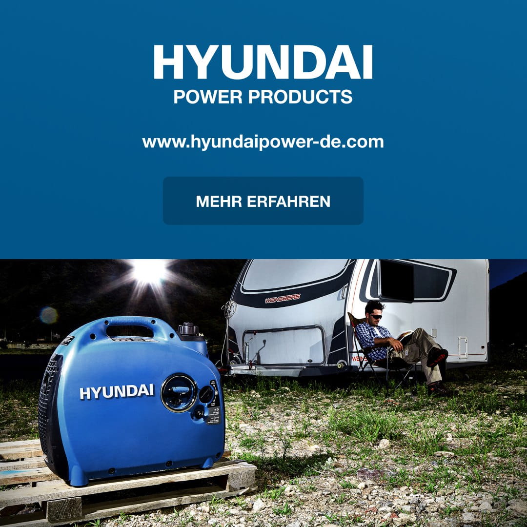 Hyundai Power Products banner above a campsite featuring a blue portable generator and a man sitting by a caravan.
